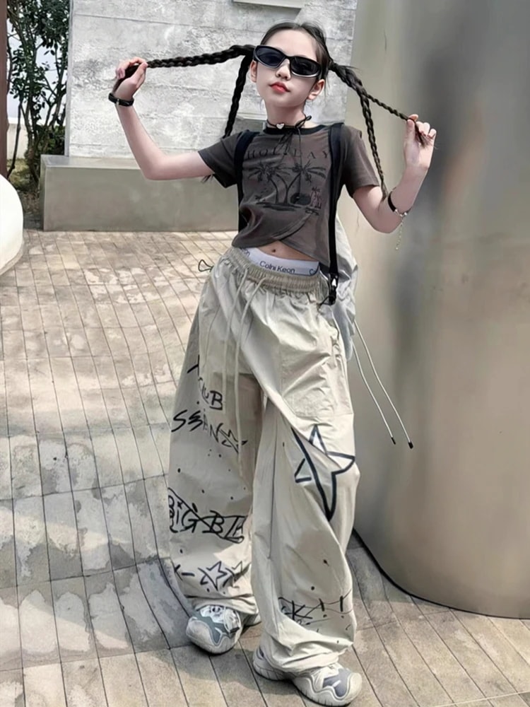 女の子のクールな格好のスーツ2025新型の夏の女の子の不規則な半袖のtシャツの子供のストレートなズボンの揚げ物の2つのセット