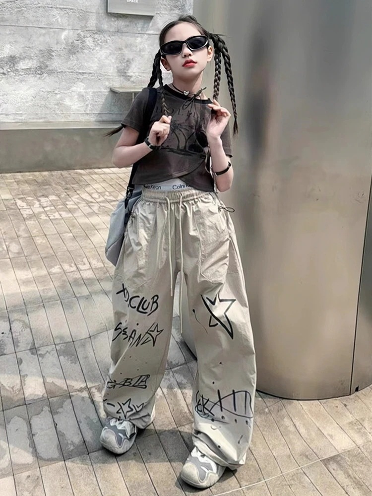 女の子のクールな格好のスーツ2025新型の夏の女の子の不規則な半袖のtシャツの子供のストレートなズボンの揚げ物の2つのセット