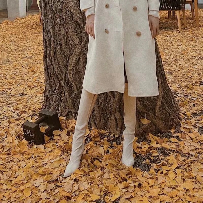 はらはらとした白い長靴の女性の新型ハイヒールがやせているブーツの騎士靴の先が膝を越えて冬になる はらはらとした白い長靴の女性の新型ハイヒールがやせているブーツの騎士靴の先が膝を越えて冬になる