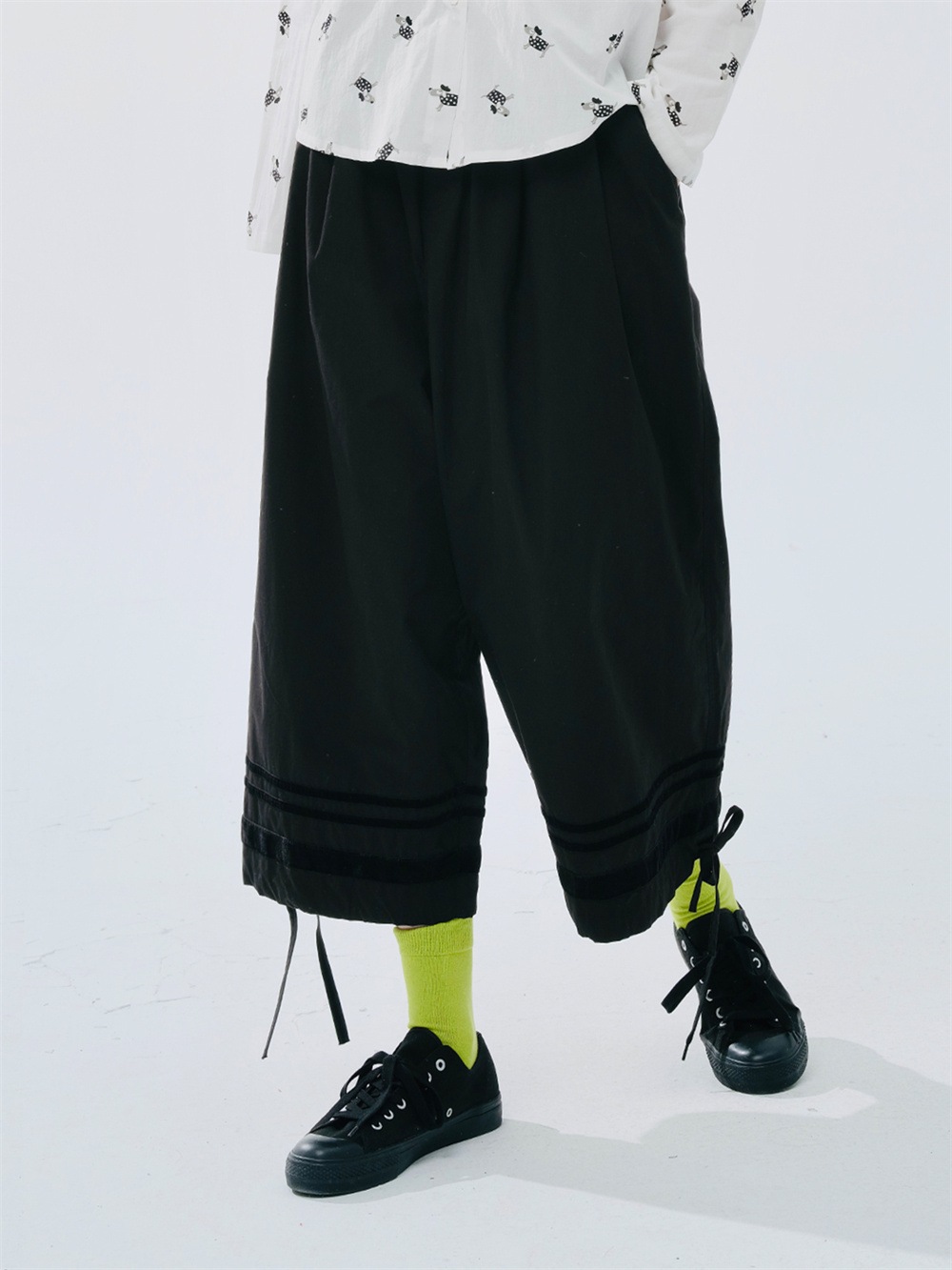 細いストライプの入った黒色のゆったりしたワイドレッグパンツ