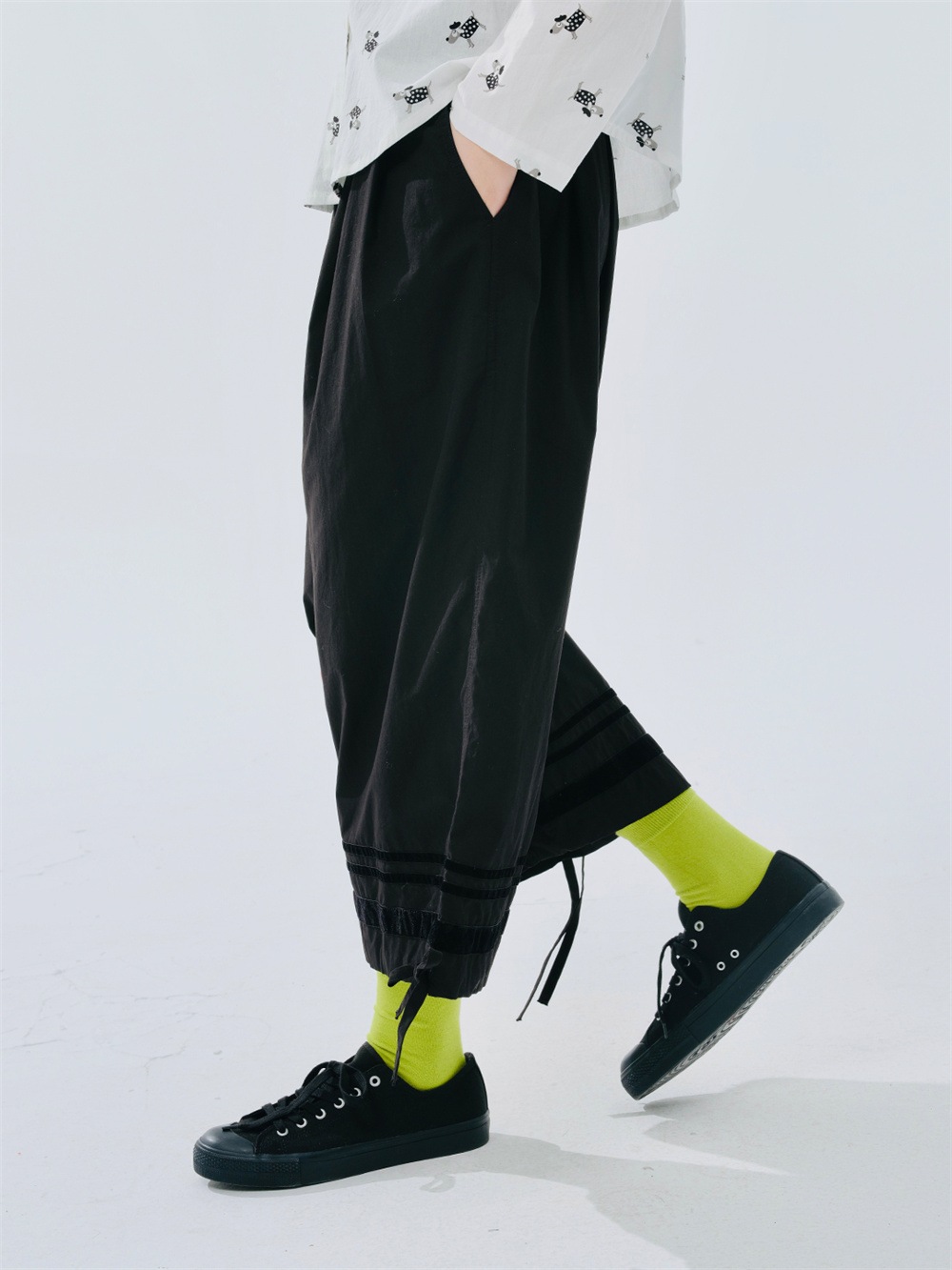 細いストライプの入った黒色のゆったりしたワイドレッグパンツ