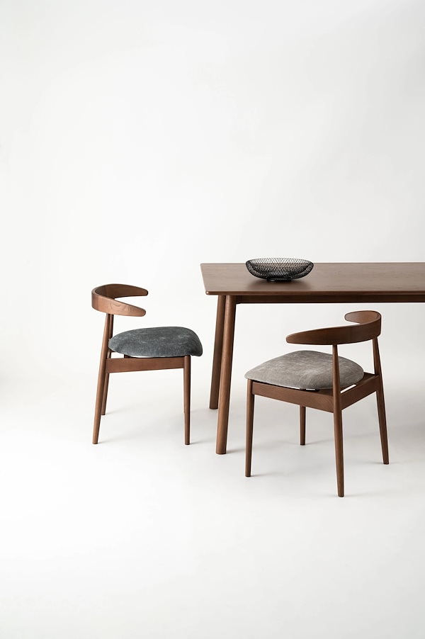 肘掛けをテーブルに掛けて脚を浮かせるシンプルモダンなダイニングチェア form