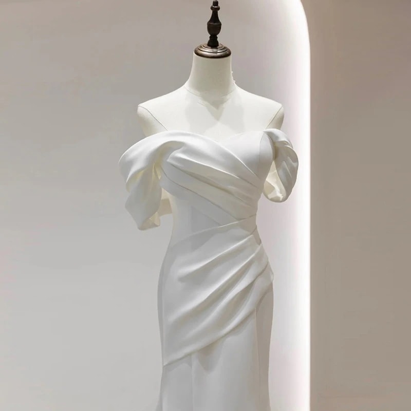 肩の軽いウェディングドレスの花嫁は簡単にサテンの尾の気質を身に着けて客を迎えます