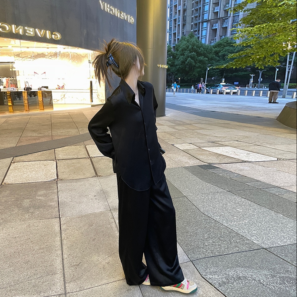 レディースシャツクールガールを引っ張る着やすい酢酸黒シャツはゆったりとした上着の女性である