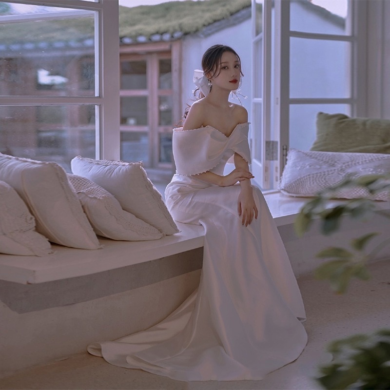サテンの肩の軽いウェディングドレスの超仙森系の白い小さい尾を引いて外に出ます