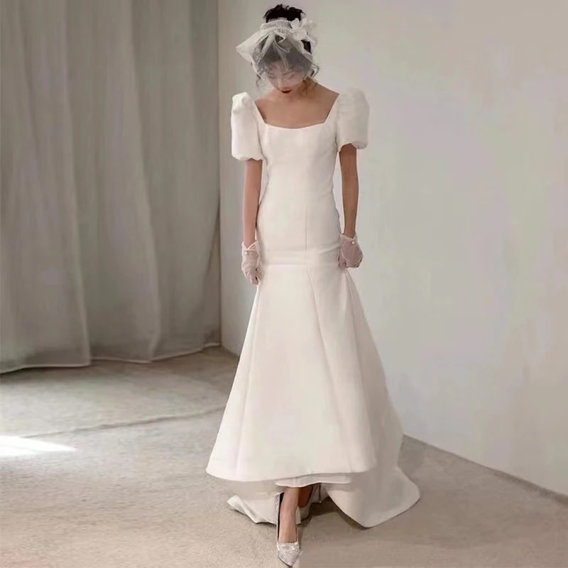 フランス式の軽いウェディングドレスの春のサテンの白いレトロな宮廷風の修身の新婦の旅は簡単な尾のドレスをたたきます