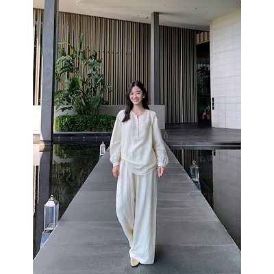 怠惰な気質のゆったりしたvネックのシャツの女性は腰を緩めてカジュアルにゆったりしています