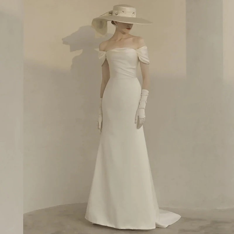 フランスのレトロなウェディングドレスの新婦の新型の白いサテンの肩は身を修めて小さい尾を引きずって外に出ます