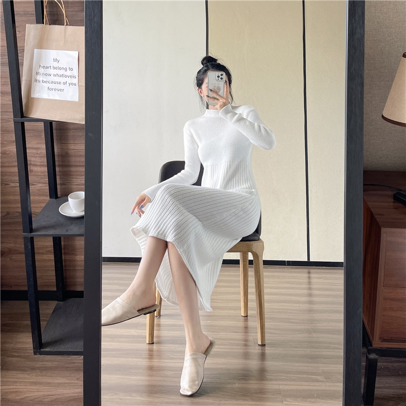 秋冬の新型気質の半高襟の中に長いニット長袖ワンピースのセータードレスの女性がいます