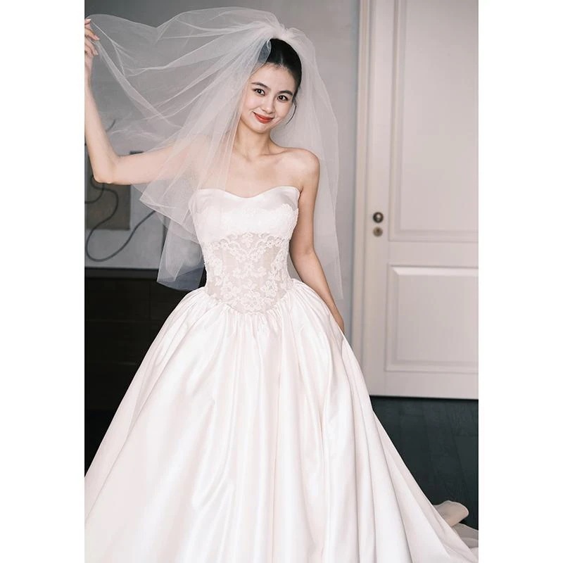 フランス式のセクシーなサテンの軽いウェディングドレスの春の新型のシンプルな結婚の主な紗の新婦は胸を拭いて客を迎えます