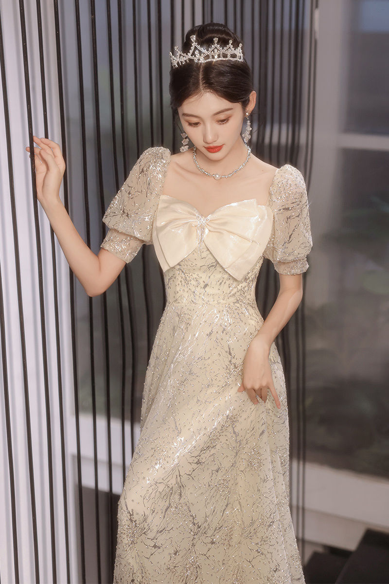 宴会のタキシードの女性の高級感の金は誕生日を司会します