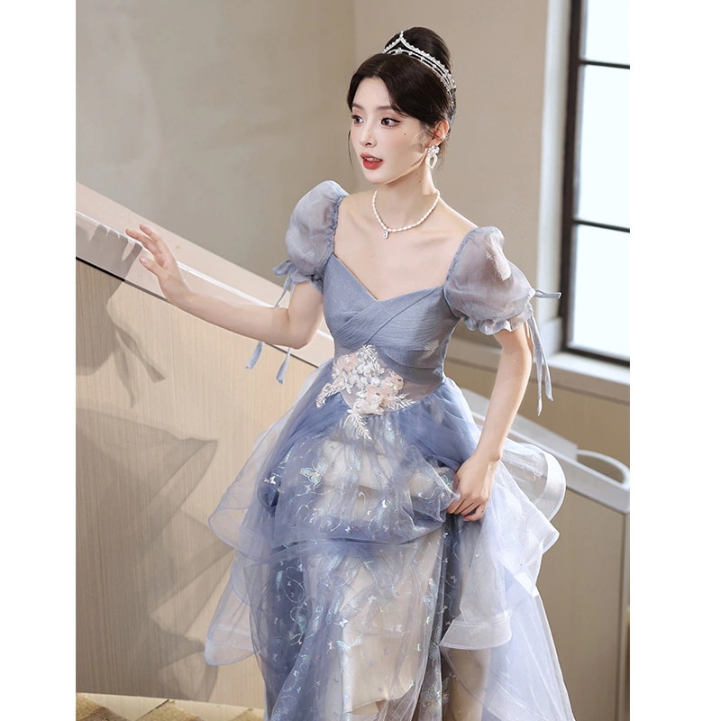 青いドレスのスカートの女性は贅沢で高級な年次総会の司会者の声楽芸は成人式の高級感のある宴会を受験した