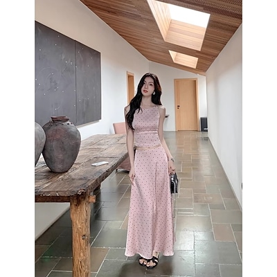 ムルバン波点ストラップの女性は袖なしの上着を身に着けています