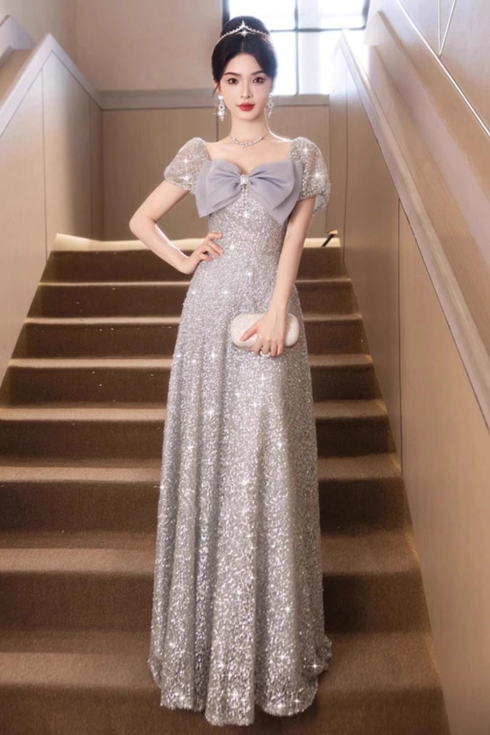 婚約パーティードレスのスカートの女性は豪華な小衆の銀色の明るい映画の敬酒服の娘が宴会の雰囲気を司会します