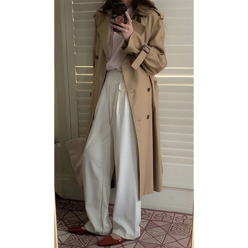 気質のカーキ色のトレンチコートの女性の早秋の女性感が小さいです