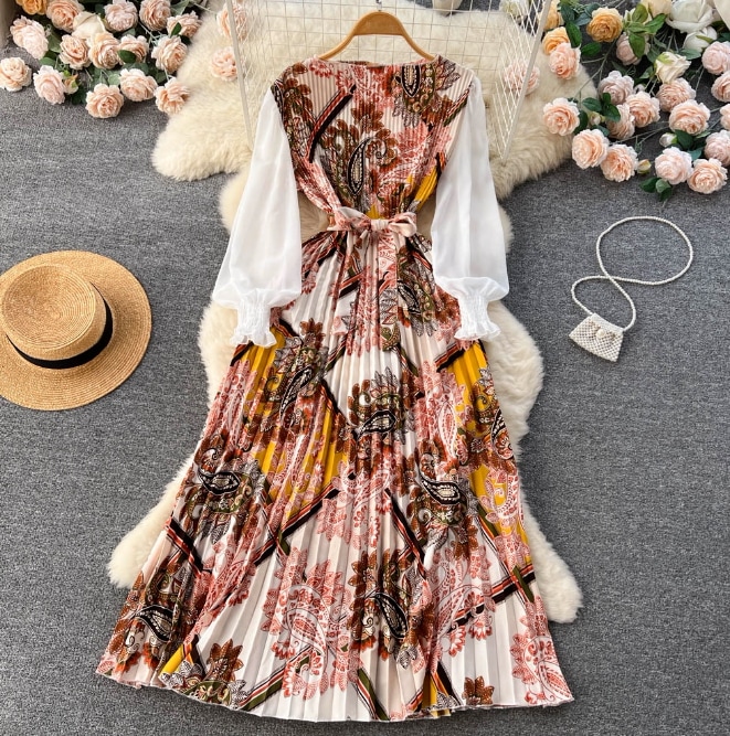 春服新型民族風のプリントのワンピースの女性の結び目の花の図案は腰の泡の袖の大きい振り子の百のしわの長いスカート