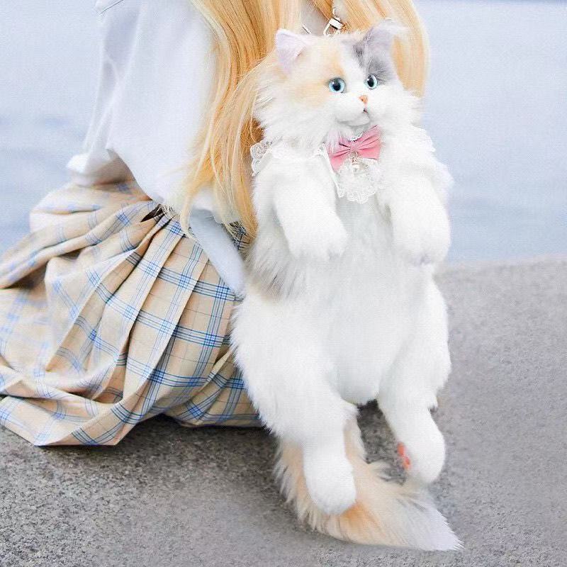 淡い三花猫のリュックサックのぬいぐるみのぬいぐるみが彼女の誕生日サプライズをプレゼントします