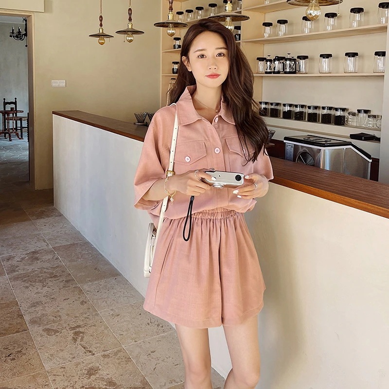 ピンクの半袖シャツと半ズボンのセット女子用の物で今の流行りでファッション的でノンビリとしたレラックス感のある甘い雰囲気のスタイルのセットアップです