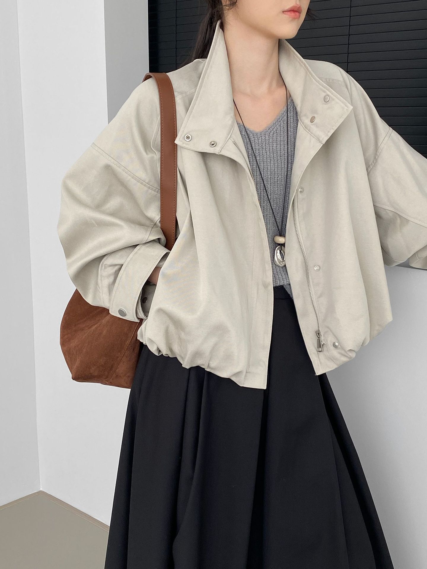 風スタンドカラーのつぼみ型ショートトレンチコート女性向けデザインでコウモリ袖とゆったりした裾が特徴のコクーンシルエット