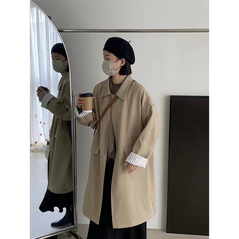 高級感のある色合わせで腰を絞ってひもを引く中長いスタイルの女性の郭形膝を越えたコートの女性