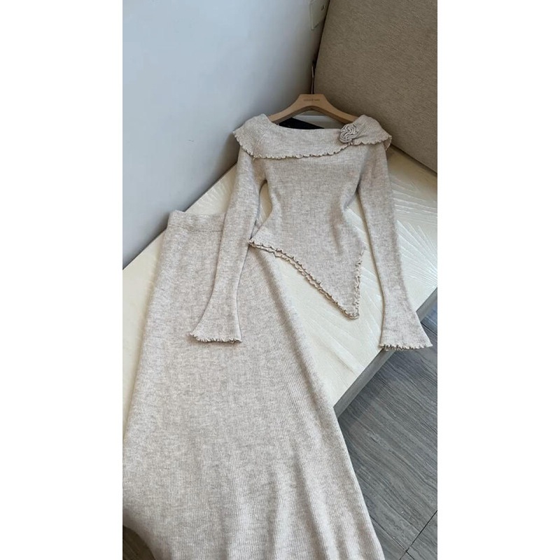 春と秋向けのフレンチスタイルのフェミニンなツーピーススーツイレギュラーなオフショルダーのニットトップとハイウエストでスタイルを美しく見せてくれるスカート