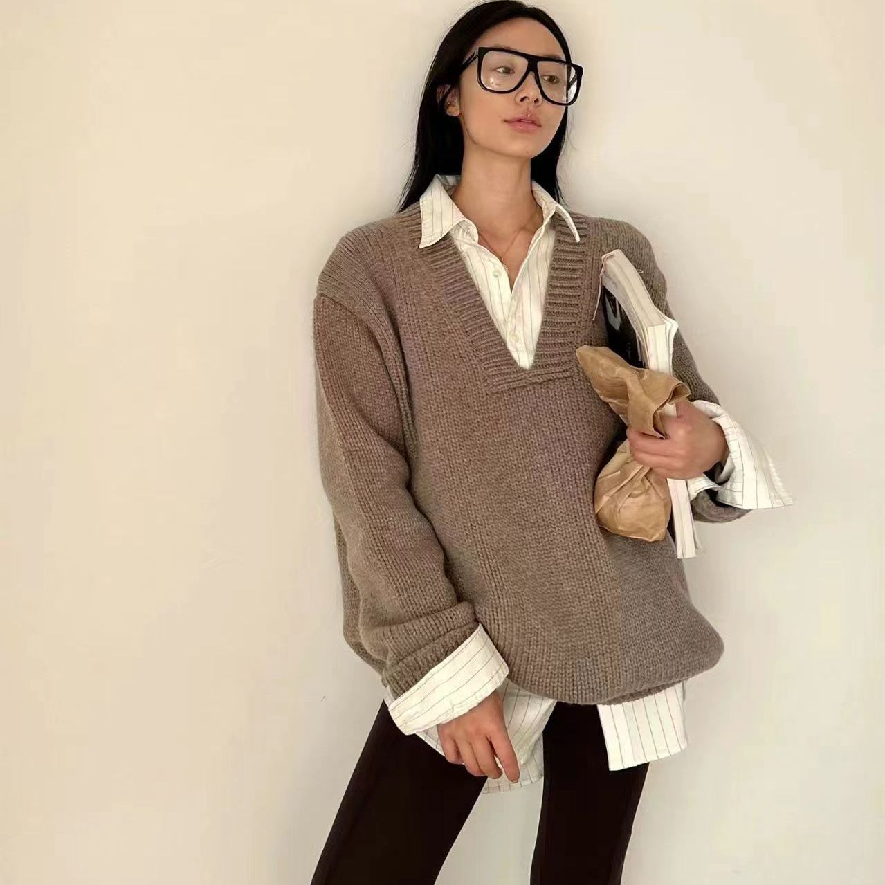 ウールのセーターはフランスの広い形のvネックのゆったりしたニットのセーターを着ています