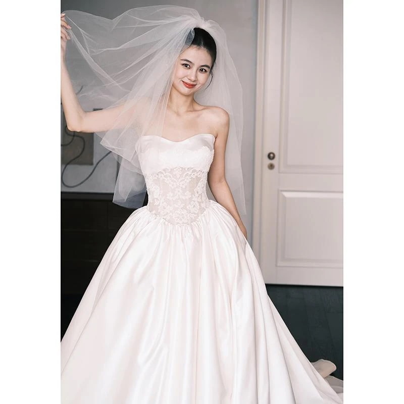 フランス式のセクシーなサテンの軽いウェディングドレスの春の新型のシンプルな結婚の主な紗の新婦は胸を拭いて客を迎えます