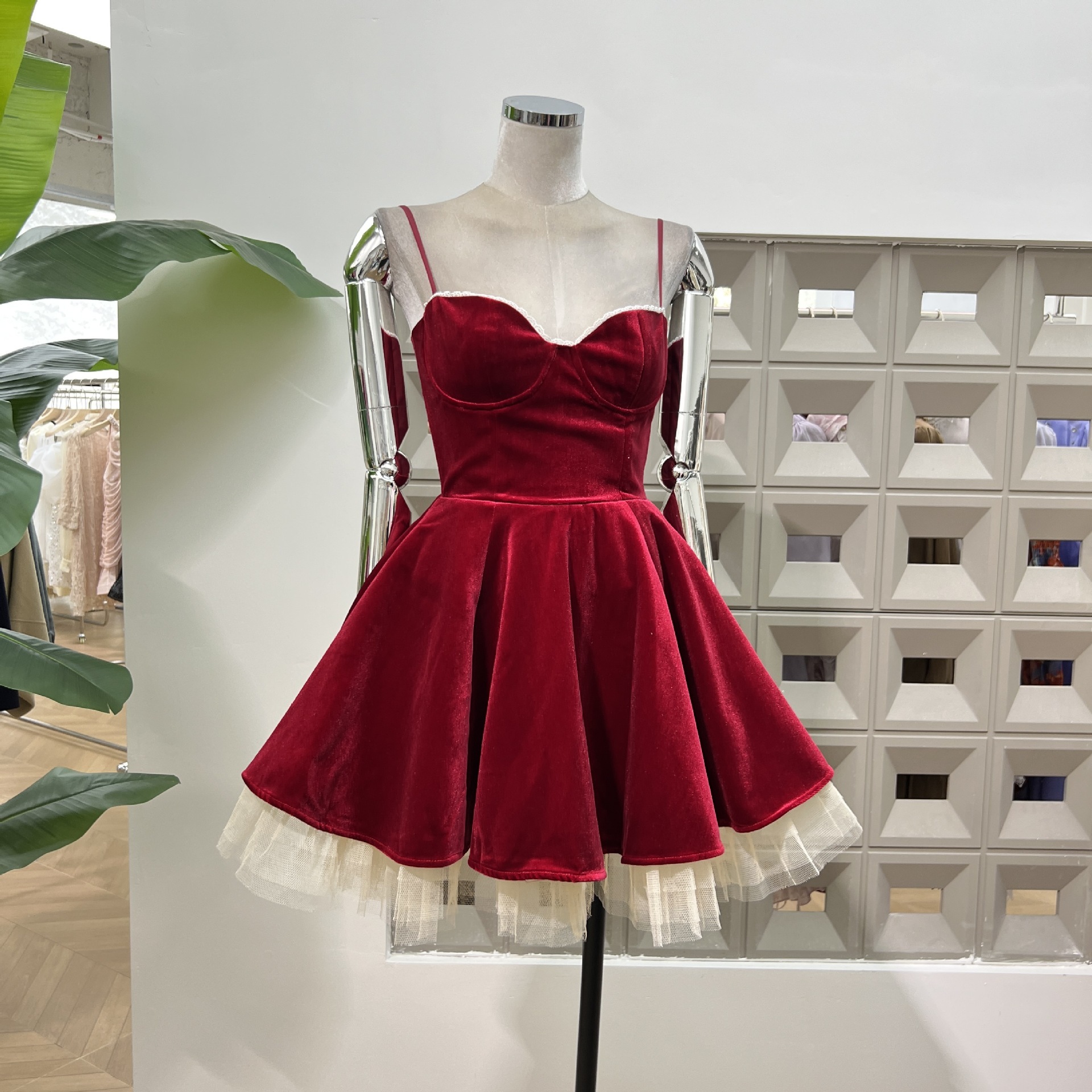 成人式の洋風がきれいなベルベットの赤い蓬蓬のストラップの低い胸のワンピースの網糸スカートが腰の秋を支えている