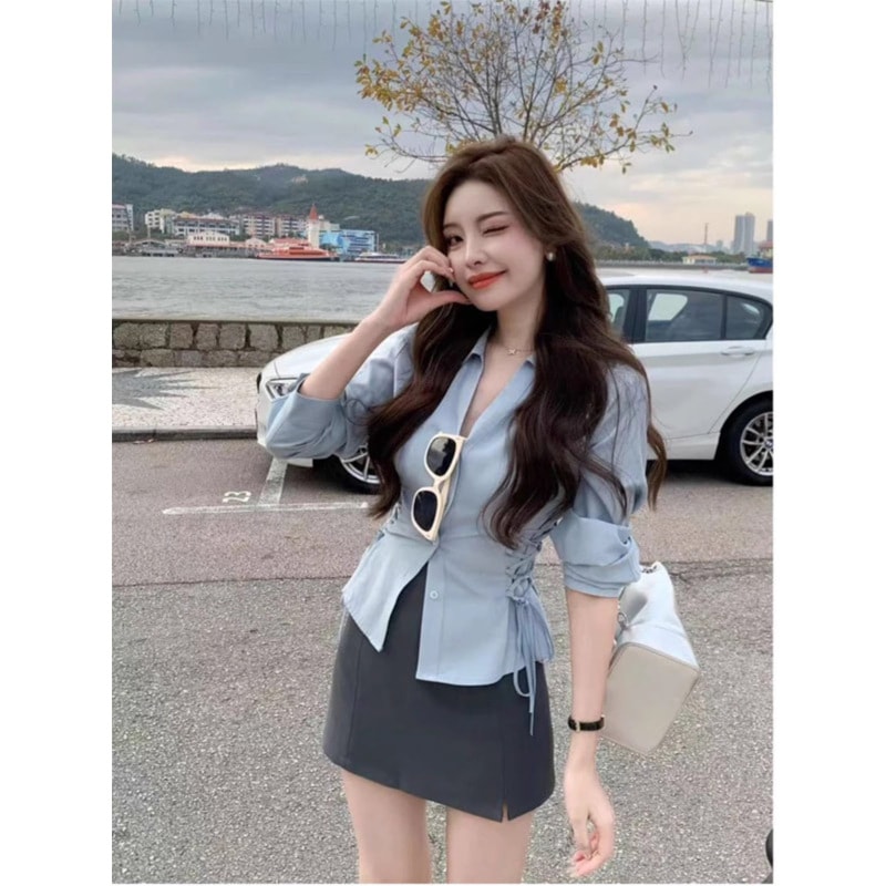 青色の長袖のシャツの女性の春の服の新型の超火のデザイン感の小さい衆は腰の上着を締めます