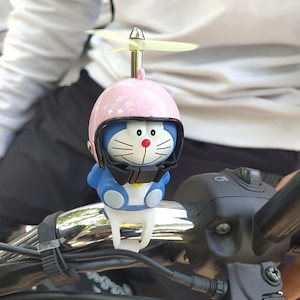 【2枚ご購入で100円OFF】ドラえもんバイク小黄鴨車載振り子電気自動車が猫のヘルメット竹トンボの装飾品になった